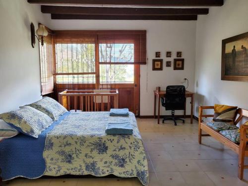 a bedroom with a bed and a desk and a window at Hermosa casona sobre la represa la Esmeralda in Somondoco