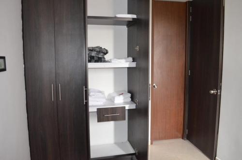 a room with a closet with wooden doors and shelves at Vacaciona a 3 minutos del Parque del Cafe in Armenia
