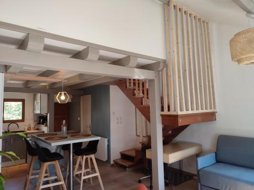 a living room with a staircase with a table and chairs at L'Absolu in Orvault