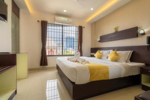a bedroom with a large bed with a window at Kay Pee's Grande in Cochin