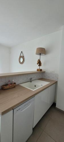 a kitchen with a sink and a lamp on a counter at Appartement Port-Mer près des plages in Cancale