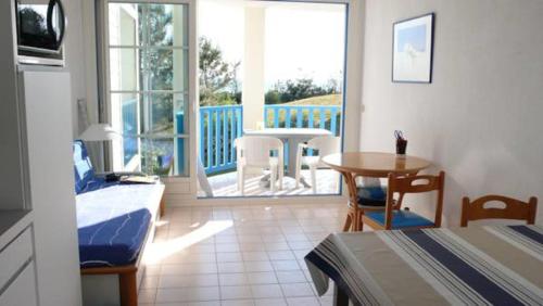 a room with a bed and a table and a balcony at Appartement Figure de proue, près Les Sables d Olonne, Talmont saint Hilaire in Talmont
