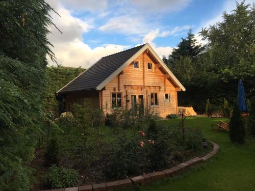 a wooden house with a garden in front of it at Chalet Ons Oekje in Vrouwenpolder