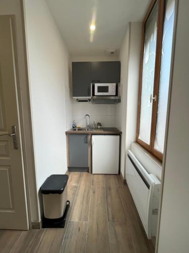 a small kitchen with a sink and a microwave at Appartement rénové à 15 min de Lyon in Saint-Fons