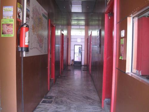 an empty hallway with red walls and a fire extinguisher at Hotel Shiv Ganga in Rishīkesh