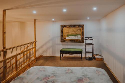 a bedroom with a chair and a painting on the wall at The Downtown Nest in Cluj-Napoca