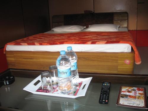 a table with two bottles of water and a bed at Hotel Shiv Ganga in Rishīkesh