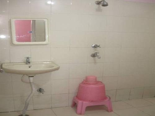 a bathroom with a pink stool next to a sink at Hotel Shiv Ganga in Rishīkesh