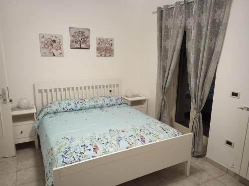 a white bedroom with a bed and a window at B&B COLLE TARIGNI in Manoppello