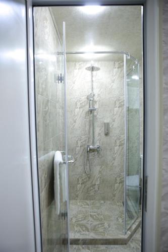 a shower with a glass door in a bathroom at Opera Avenue Hotel in Yerevan