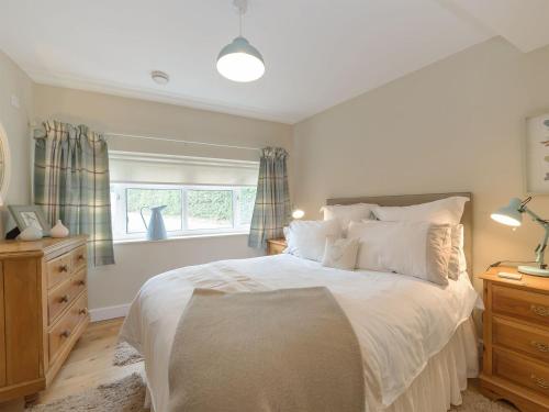a bedroom with a large bed and a window at Mortimer Trail Mews in Aymestrey