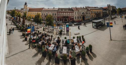 a group of people sitting at tables on a city street at The Downtown Nest in Cluj-Napoca