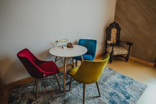une chambre avec trois chaises, une table et une table dans l'établissement The Downtown Nest, à Cluj-Napoca