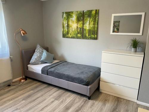 Schlafzimmer mit einem Bett, einer Kommode und einem Spiegel in der Unterkunft Work & Study Apartment in Karlsruhe
