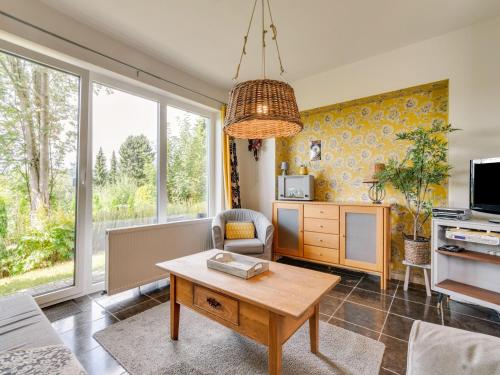 a living room with a table and a tv at Cosy holiday home with terrace in Winterberg in Winterberg