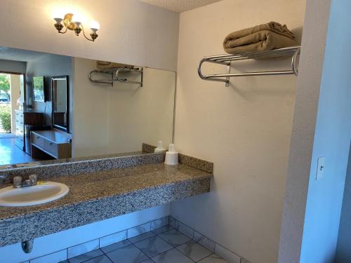 a bathroom with a sink and a mirror at Howard Johnson by Wyndham Azusa in Azusa