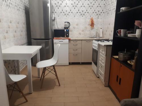 a kitchen with a table and a white counter top at Уютные апартаменты 5 микрорайон in Aktau