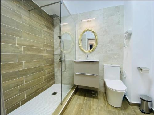 a bathroom with a toilet and a glass shower at Alezzi Yacht Apartments with Sea View Near the Beach in Năvodari