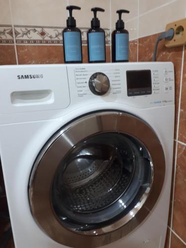 a washing machine with four bottles on top of it at Уютные апартаменты 5 микрорайон in Aktau