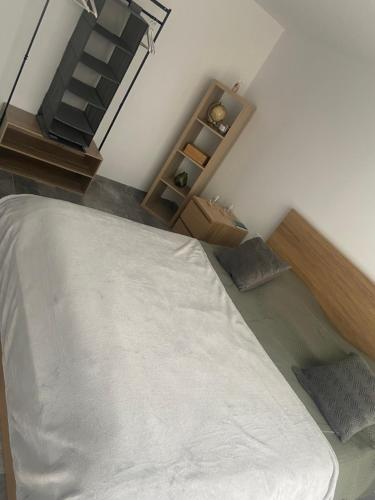 1 dormitorio con 1 cama blanca grande y escaleras en Maison Climatisée proche du lac de Freminville, en Tignieu-Jameyzieu