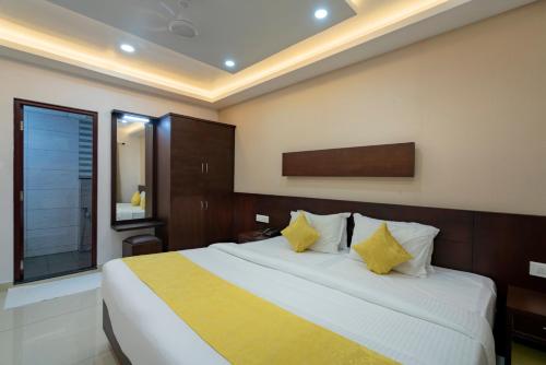 a bedroom with a large white bed with yellow pillows at Kay Pee's Grande in Cochin