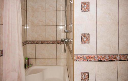 a bathroom with a tub and a shower with a shower curtain at Cozy Home In Orzysz With Lake View in Orzysz