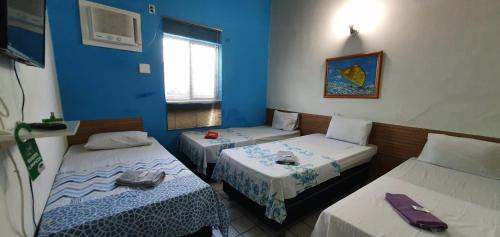 3 camas en una habitación con paredes azules en Casa do Meio Pousada, en Recife