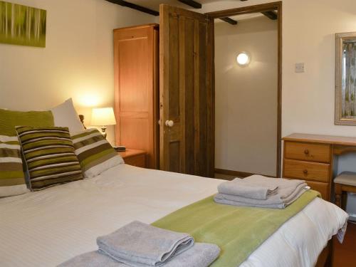 a bedroom with a bed with towels on it at Moorview Cottage in Marytavy