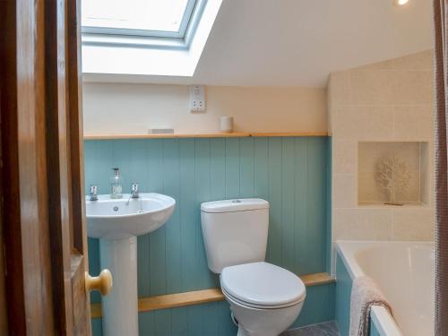 a bathroom with a toilet and a sink and a tub at Moorview Cottage in Marytavy