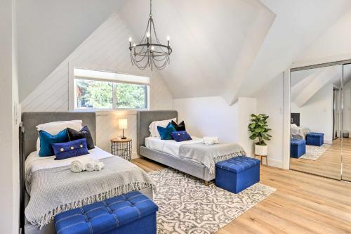 Un dormitorio con dos camas y una lámpara de araña. en Luxe Timberland Villa with Lake Arrowhead Access!, en Lake Arrowhead