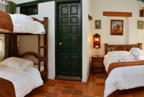 a room with two bunk beds and a green door at Hotel Antonio Nariño in Villa de Leyva