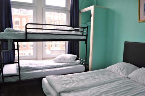 two bunk beds in a room with a window at Bell House Hostel in London