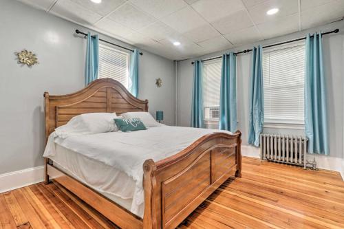 een slaapkamer met een houten bed en blauwe ramen bij Updated Stoughton Apartment with Shared Yard! in Stoughton
