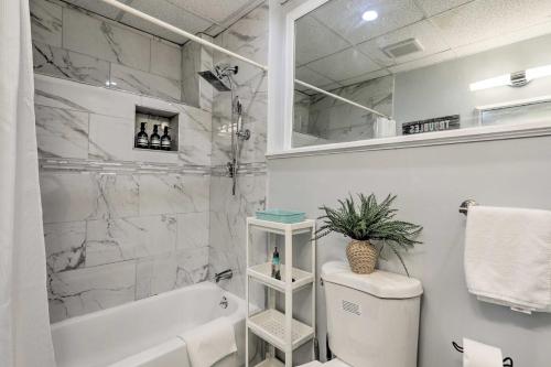 baño blanco con bañera y aseo en Updated Stoughton Apartment with Shared Yard!, en Stoughton