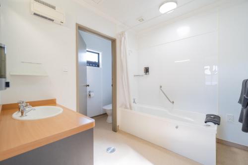 La salle de bains est pourvue d'un lavabo et d'une baignoire. dans l'établissement Te Anau Motel & Apartments, à Te Anau