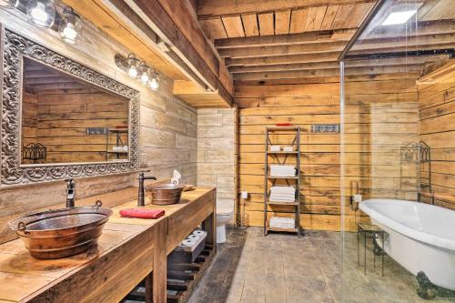 a bathroom with wooden walls and a tub and a sink at Charming Jeffersonville Barndominium with Fire Pit! in Jeffersonville
