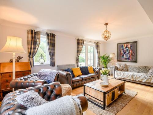 a living room with couches and a table at Appledore Cottage in Farnham