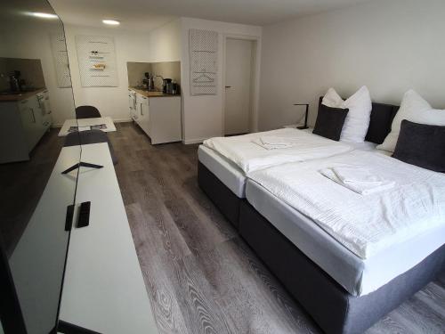- une chambre avec un grand lit et des draps blancs dans l'établissement QUELLQUARTIER, à Fulde