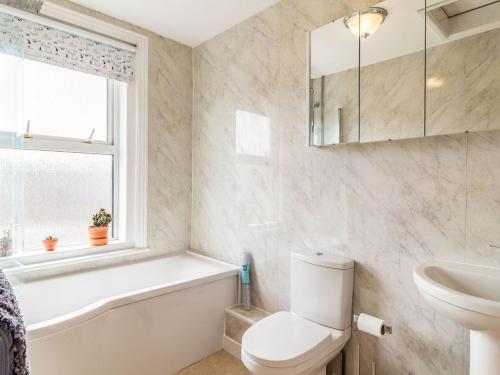 a bathroom with a tub sink and a toilet at Riversdelle in Beccles