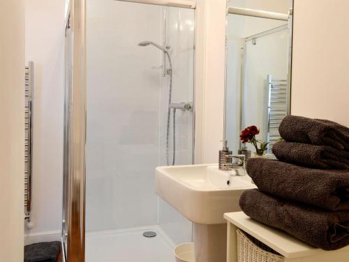 a white bathroom with a sink and a shower at Seascape in Whitehills