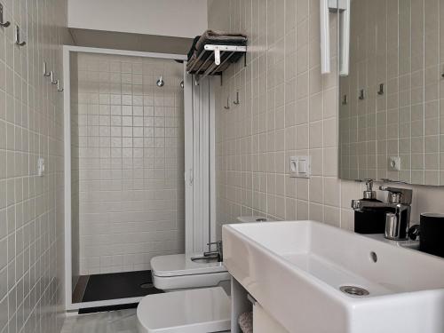 uma casa de banho branca com um lavatório e um WC em White Loft Alameda em Sevilha