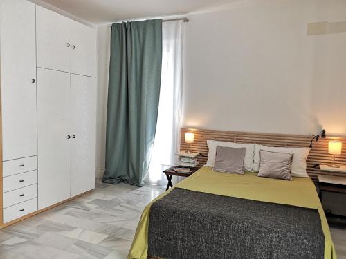 a bedroom with a bed and a large window at White Loft Alameda in Seville