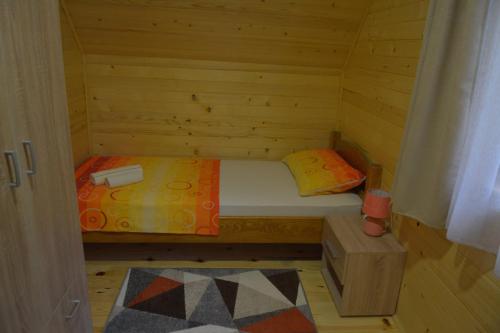 ein kleines Zimmer mit einem Bett in einer Holzhütte in der Unterkunft Dobar pogled in Bajina Bašta