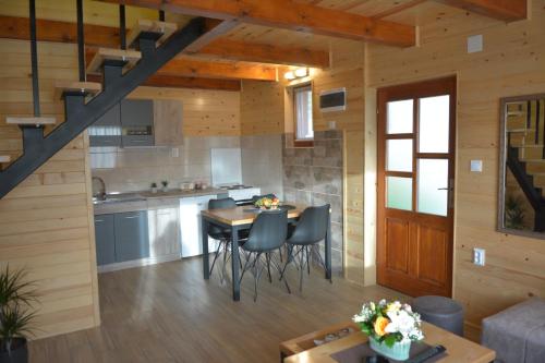 uma cozinha e sala de estar com mesa e cadeiras em Dobar pogled em Bajina Bašta