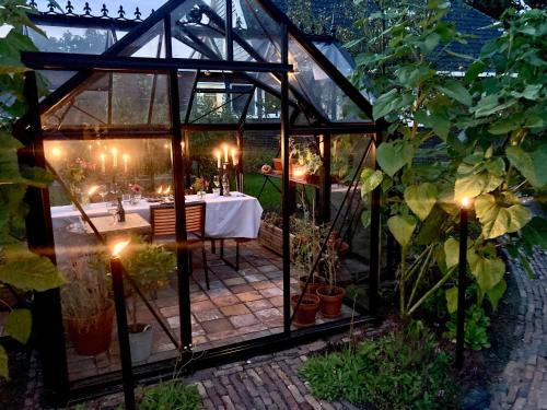 a greenhouse with a table in it in a garden at De Vijf Suites in Elp