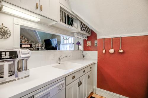eine Küche mit einem Waschbecken und einer roten Wand in der Unterkunft Brittany Place Condo - Great Downtown Location - On Main St in Breckenridge