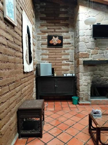 a patio with a brick wall and a fireplace at Cabañas y habitaciones Los Cedros in Zacatlán