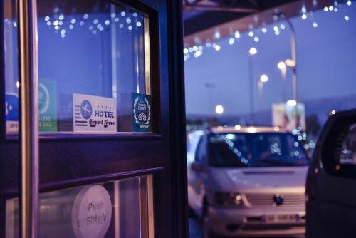 a reflection of cars in a window of a store at Hotel Airport Tirana in Rinas