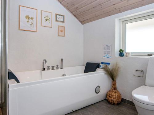 een badkamer met een wit bad en een toilet bij 7 person holiday home in Hejls-By Traum in Hejls