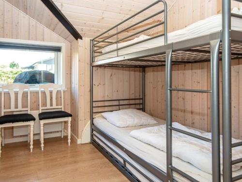 een stapelbed in een kamer met een tafel en stoelen bij 7 person holiday home in Hejls-By Traum in Hejls
